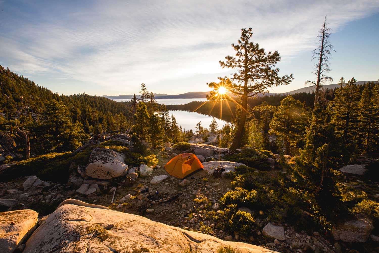 sun rising over lake side campsite